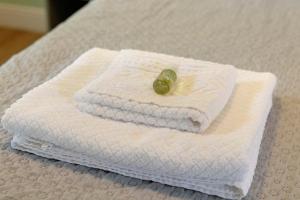 a white towel with a green button on it on a bed at Bc Garda House in Peschiera del Garda