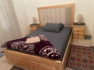 ein Bett in einem Schlafzimmer mit zwei Nachttischen und zwei Lampen in der Unterkunft Dâr Mâbâ in Tazenakht