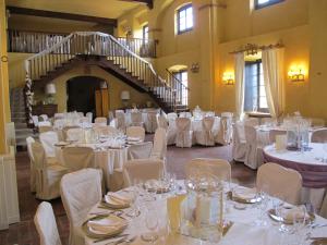Tagliolo MonferratoにあるCastello di Tagliolo Wine Resortの白いテーブルと椅子が備わる宴会場
