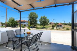 a patio with a table and chairs and a view of a street at ELYSIAN luxury apartments in Paliouri