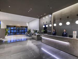 two women standing in the lobby of a building at Mercure Nanjing Olympic EXPO in Nanjing