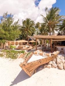 a beach with chairs and umbrellas on the beach at Mala Boutique Hotel in Bwejuu