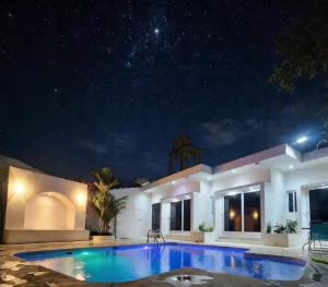 a villa with a swimming pool at night at Vidalta Hotel Boutique in Retalhuleu