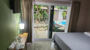 a bedroom with a bed and a view of a pool at Vidalta Hotel Boutique in Retalhuleu +12 photos