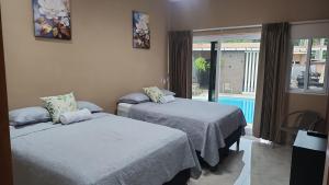 a room with two beds and a window with a pool at Vidalta Hotel Boutique in Retalhuleu