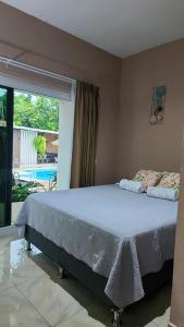 a bed in a bedroom with a view of a pool at Vidalta Hotel Boutique in Retalhuleu