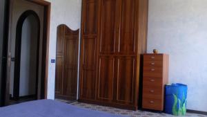 a bedroom with a wooden cabinet and a dresser at Casa Vacanze Corso Umberto in Giardini Naxos