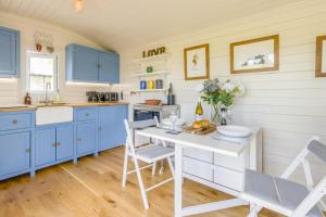 a kitchen with blue cabinets and a white table at 1 Bed in Knighton oc-51898 in Beguildy