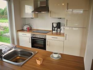 a kitchen with white cabinets and a sink and a counter at Auszeit - Nordhorn in Nordhorn