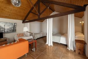 a bedroom with two beds and a couch and a tv at Flat 23 in Bombarral