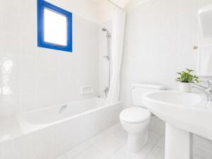 a white bathroom with a toilet and a sink at Villa Charoula Ena Large Private Pool AC WiFi in Polis Chrysochous +8 photos