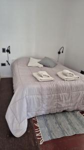 a large bed with two lamps on top of it at Cubil Amarillo. Casa conteiner 1 dormitorio in General Roca