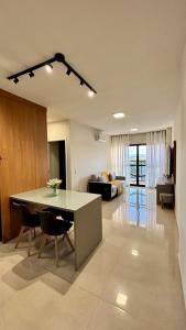 a kitchen and living room with a table and a couch at Apartamento completo Studio 9 centro Pouso Alegre in Pouso Alegre