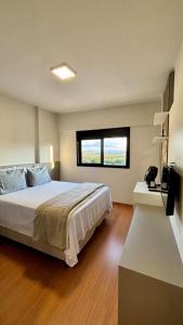 a bedroom with a large bed and a window at Apartamento completo Studio 9 centro Pouso Alegre in Pouso Alegre +42 photos