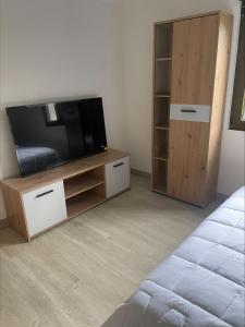 a living room with a tv and a wooden cabinet at El capricho de la Providencia in Gijón