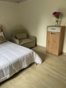 a bedroom with a bed and a chair and a table at El capricho de la Providencia in Gijón