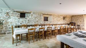 a dining room with tables and chairs and a stone wall at Gîte des 3 Suissesses in Saint-Paul