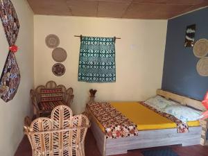 ein Schlafzimmer mit Bett, Fenster und Stühlen in der Unterkunft Jedd Palace in Kpannou