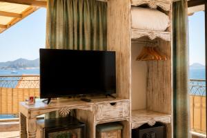 a living room with a flat screen tv on a entertainment center at Payam Agora Hotel Room Only , Shared Terrace & Kitchen in Kaş
