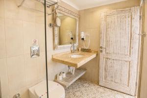 a bathroom with a sink and a toilet and a mirror at Payam Agora Hotel Room Only , Shared Terrace & Kitchen in Kaş +64 photos