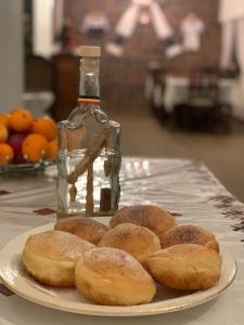a plate of donuts on a table with a bottle at Carpathian Soul Maramures in Bogdan Vodă