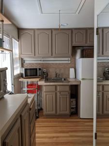 a kitchen with wooden cabinets and a white refrigerator at Backyard Bungalow private guest house in Riverside +12 photos