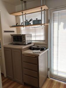 a small kitchen with a stove and a microwave at Backyard Bungalow private guest house in Riverside