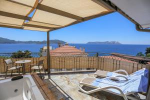 a patio with chairs and a view of the water at Payam Agora Hotel Room Only , Shared Terrace & Kitchen in Kaş