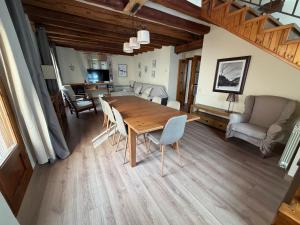a living room with a wooden table and chairs at Cal Quimet in Rialp