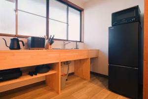 a kitchen with a black refrigerator and a wooden counter at rinne 北軽井沢 Forest3 in Tsumagoi +26 photos