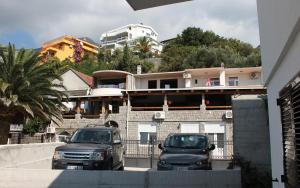 two cars parked in a parking lot in front of a building at Saga Del Mare in Sutomore