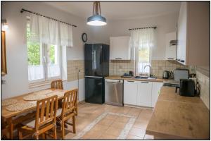 a kitchen with a table and a table and chairs at Mazury- dom wakacyjny in Pisz