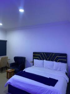 a bedroom with a large bed and a blue light at Miad Hotels in Port Harcourt