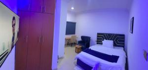 a bedroom with a bed and a chair and a tv at Miad Hotels in Port Harcourt