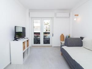 a white living room with a bed and a tv at Old Town Spot Apartment by Stay ici in Albufeira