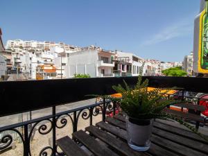 a potted plant sitting on a wooden bench on a balcony at Old Town Spot Apartment by Stay ici in Albufeira