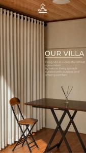 a table and two chairs in front of a curtain at KALUNA cabin in Kejajar +1 photo