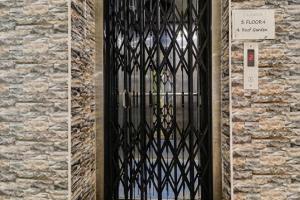 a door with a black iron gate on a brick wall at Hotel Amaravathi Residency in Guntūr +2 photos