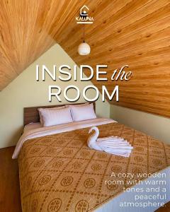 a room with a bed with a swan on it at KALUNA cabin in Kejajar
