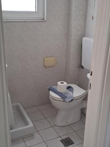 ein Badezimmer mit Toilette, Badewanne und Fenster in der Unterkunft Μeltemi in Glífa