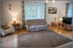 a living room with a couch and a tv at Mazury- dom wakacyjny in Pisz