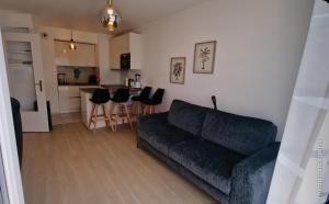 a living room with a couch and a kitchen at Paris Ouest Bezons Appartement entier in Bezons