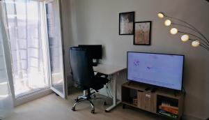 a room with a desk and a television and a chair at Paris Ouest Bezons Appartement entier in Bezons +7 photos
