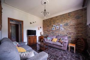 a living room with two couches and a brick wall at Vita Lenta in Biassa