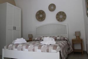a bedroom with a bed with towels on it at Dimora Letizia, Apulian Rooms in Sammichele di Bari