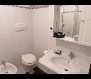 a white bathroom with a toilet and a sink at Da Carlo in Pietralunga