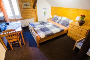 a bedroom with a bed and a table and a desk at Maxova Bouda in Josefŭv Dŭl