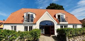 a white house with an orange roof at Inselhotel Brummers Anneks in Haderslev