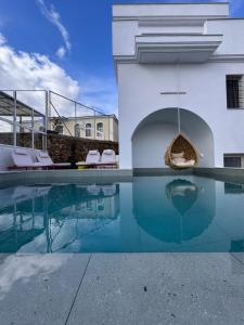 a swimming pool with a swing in a building at Rozmari Suites in Agia Galini