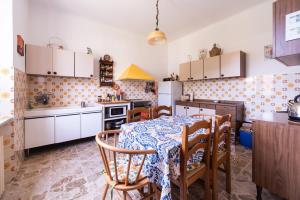 a kitchen with a table and chairs and a kitchen with white cabinets at Vita Lenta in Biassa +24 photos